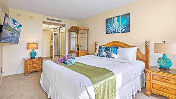 A hotel room with a large bed, two bedside tables, a mirror, and artwork on the walls.