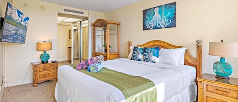 Une chambre d’hôtel avec un grand lit, deux tables de chevet, un miroir et des œuvres d’art accrochées aux murs.