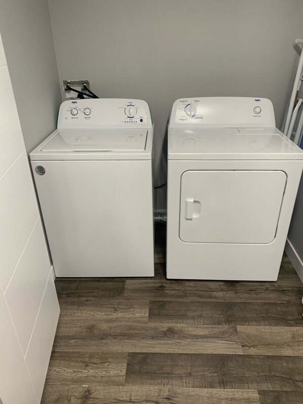 Two front-loading washing machines in a laundry room with wooden flooring.