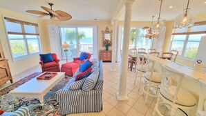 A spacious living room with a large sofa, red armchairs, and a dining area with white chairs. - ☆Oceanfront Serenity☆ Private Pool & Beach Walkway (Myrtle Beach)