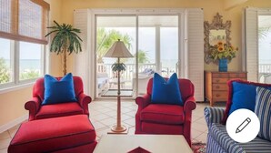 A room with two red armchairs, a striped sofa, a lamp, a dresser, and a large window with a view of the sea. - ☆Oceanfront Serenity☆ Private Pool & Beach Walkway (Myrtle Beach)