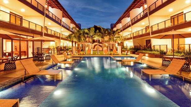 A hotel pool area with lounge chairs and a clear view of the pool. - Porto das Dunas Boutique Praia Hotel (Aquiraz)