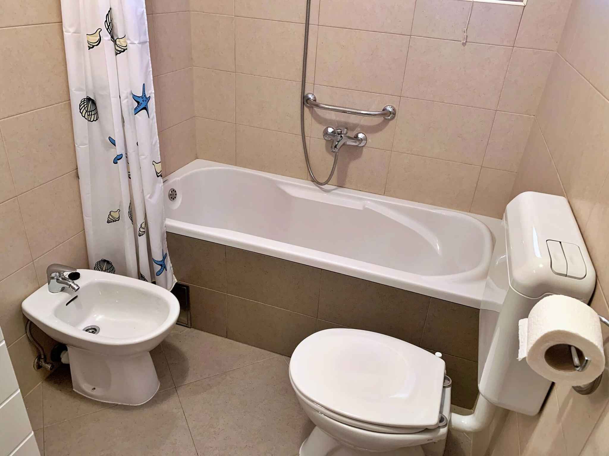 A bathroom with a bathtub, a toilet, a bidet, and a shower.