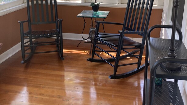A room with two rocking chairs, a small table with a potted plant, and a lamp on a side table. - Charming house on Beautiful Doty Island (Neenah)