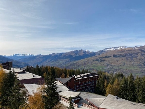 A mountain lodge with multiple buildings, surrounded by trees and mountains in the background.