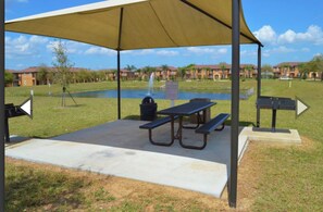 Relax under the canopy in this serene outdoor pavilion, featuring a picnic table and benches.