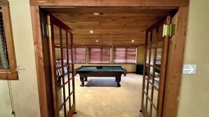 A room with a pool table, wooden ceiling, and windows with blinds. - Private lakefront home with amazing views! (Noble)