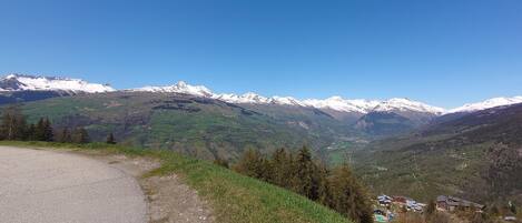 A mountain landscape with snow-capped peaks and a valley below.