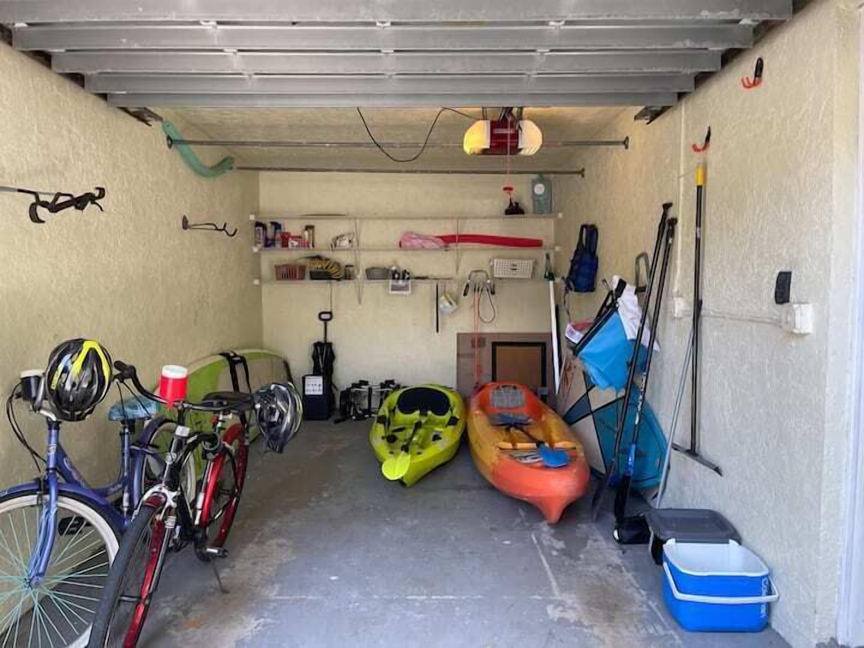 Eine Garage mit Fahrrädern, Kajaks und einer blauen Kühlbox.