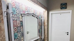 A room with a bed, a mirror, a clock, and a door. - Very nice luxury apartament (Varna)