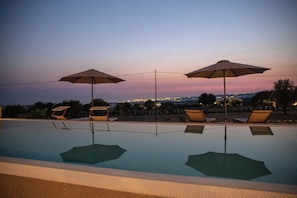 Piscine extérieure, piscine à débordement, chaises longues