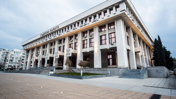 A large, modern building with a symmetrical facade, multiple windows, and a central entrance with steps. - DOWNTOWN - Compact Flat  - 2 Separate Rooms (Бургас)