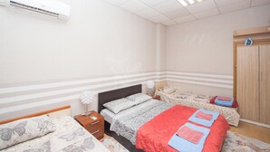 A bedroom with a bed, a nightstand, an air conditioner, a wardrobe, and a window. - DOWNTOWN - Compact Flat  - 2 Separate Rooms (Бургас)
