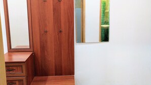 A wooden wardrobe with multiple hooks and a mirror. - DOWNTOWN - Compact Flat  - 2 Separate Rooms (Бургас)