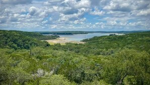 Paisatge amb vegetació abundant, un llac i una riba llunyana.