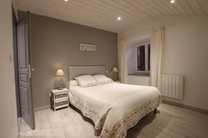 Relax in a serene bedroom with a comfortable bed, bedside tables, and a window with curtains.