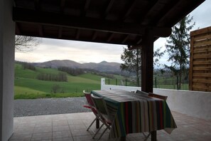Enjoy a tranquil meal on the shaded patio overlooking rolling hills and distant mountains.
