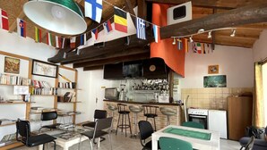 A cozy, rustic interior with a bar area, bookshelves, and a dining space.
