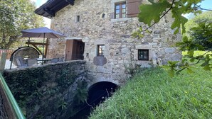 Un bâtiment en pierre doté d’un patio couvert, d’une petite fenêtre et d’une arche en pierre.
