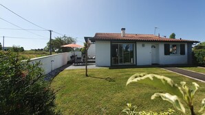 Een modern huis met een pannendak, een glazen deur en een klein terras.