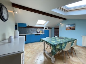 Enjoy meals in the kitchen with a dining area nearby, featuring a table and chairs.