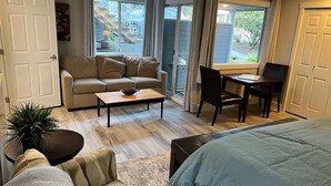 A cozy living room with a sofa, coffee table, and a dining area with a table and chairs.