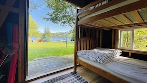 A bunk bed room with a view of a grassy area and trees. - Coby’s Cove - Four Season Cottage Huntsville Muskoka Waterfront  (Emsdale)