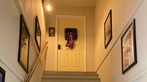 Eine Treppe mit Geländer, die zu einer Tür mit einem Kranz führt.