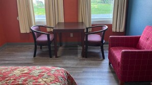 A room with a bed, a table with two chairs, a red sofa, and a window with curtains. - Kenwood Court Motel (Wilson)