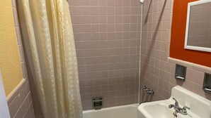 A bathroom with a bathtub, shower, and sink. - Kenwood Court Motel (Wilson)