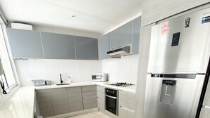 A modern kitchen with stainless steel appliances, a built-in oven, and a water dispenser. - 3TC10 Apartamento Cartagena frente al mar (Cartagena)
