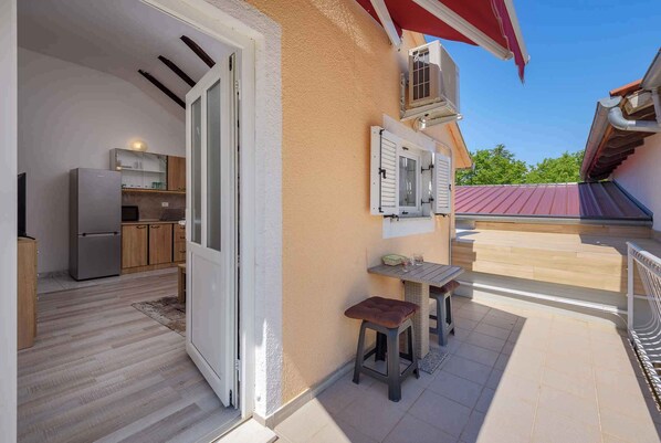 Una cucina open space con una porta scorrevole che dà su un balcone.