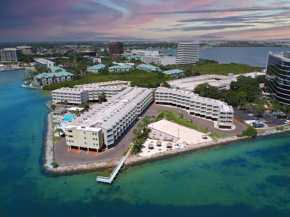 Un hotel frente al mar con varias construcciones, una piscina y un muelle.