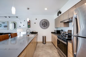 Een moderne keuken met roestvrijstalen apparatuur, houten kasten en een centraal eiland.