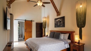 A spacious bedroom with a large bed, wooden headboard, and a ceiling fan. - Luxury Villa • Pool • Jacuzzi • Spa • Maid/Cook • 5 min from Panaca Park. (Quindío)