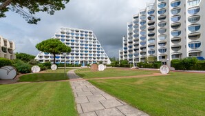 Een modern gebouw met een opvallende, gebogen gevel, omgeven door keurig onderhouden gazons en een geplaveid pad.