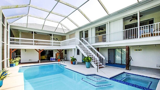 An indoor swimming pool with a glass ceiling, multiple levels, and a staircase. - Sandcastle Home on Sanibel Island in The Dunes Golf Club (Sanibel)