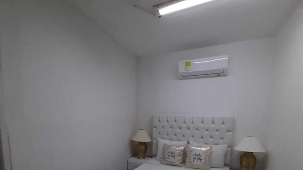 A bedroom with a bed, two bedside tables with lamps, an air conditioning unit, and a ceiling light. - 3G1-1 Apartamento Ciudad Antigua Getsemani (Cartagena)