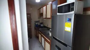 A kitchen with a refrigerator, microwave, and cabinets. - 3G1-1 Apartamento Ciudad Antigua Getsemani (Cartagena)