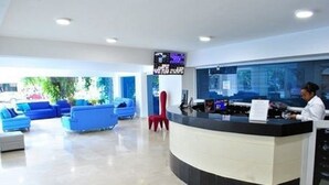 A reception area with a curved desk, blue seating, and a large window. - PH17P Penthouse Cartagena Frente al mar (Cartagena)
