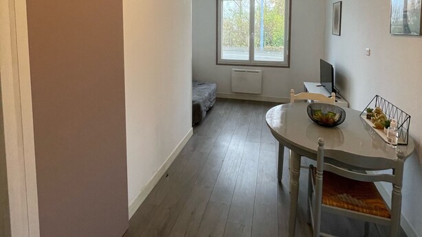 A compact living space with a dining area, a small bed, and a window providing natural light. - Studio near University and Hospital BETHUNE (Beuvry)