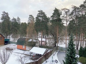 Un barrio residencial con una casa pequeña, un patio cercado y suelo cubierto de nieve.