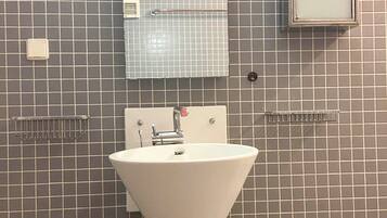 A bathroom with a white sink, a mirror, and a towel rack.