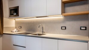 A modern kitchen with a stainless steel sink, built-in microwave, and under-cabinet lighting.