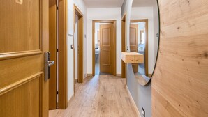 Un couloir avec des portes en bois, un miroir et un mur en bois.