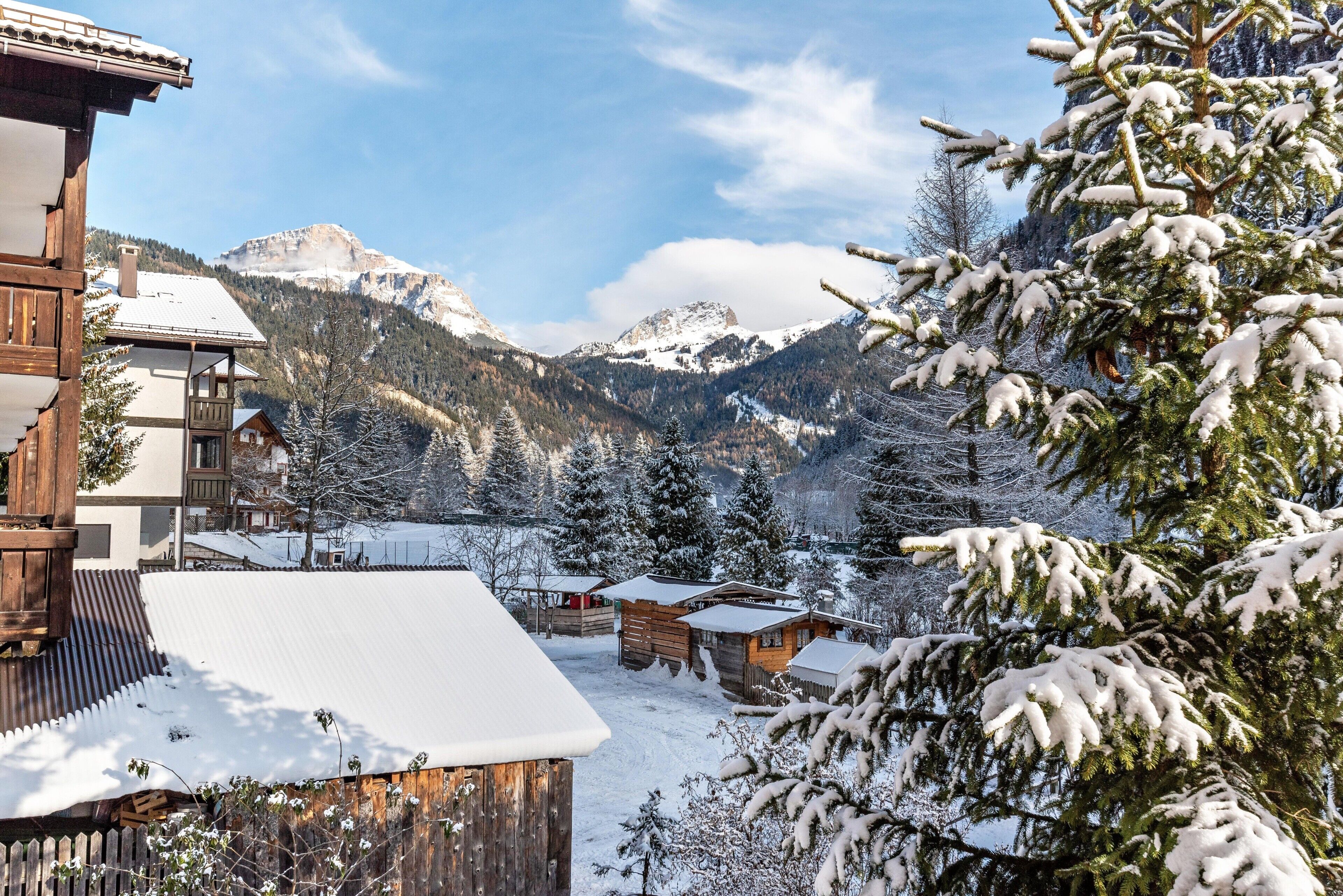 A snowy mountain village with wooden buildings and snow-covered trees.