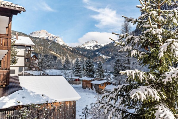 A snowy mountain village with wooden buildings and snow-covered trees.