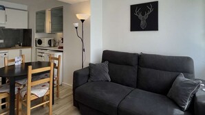 A compact living space with a kitchenette, a dining area, and a sofa. - ASH - Cosy studio - La Menandière (Alpe d'Huez)