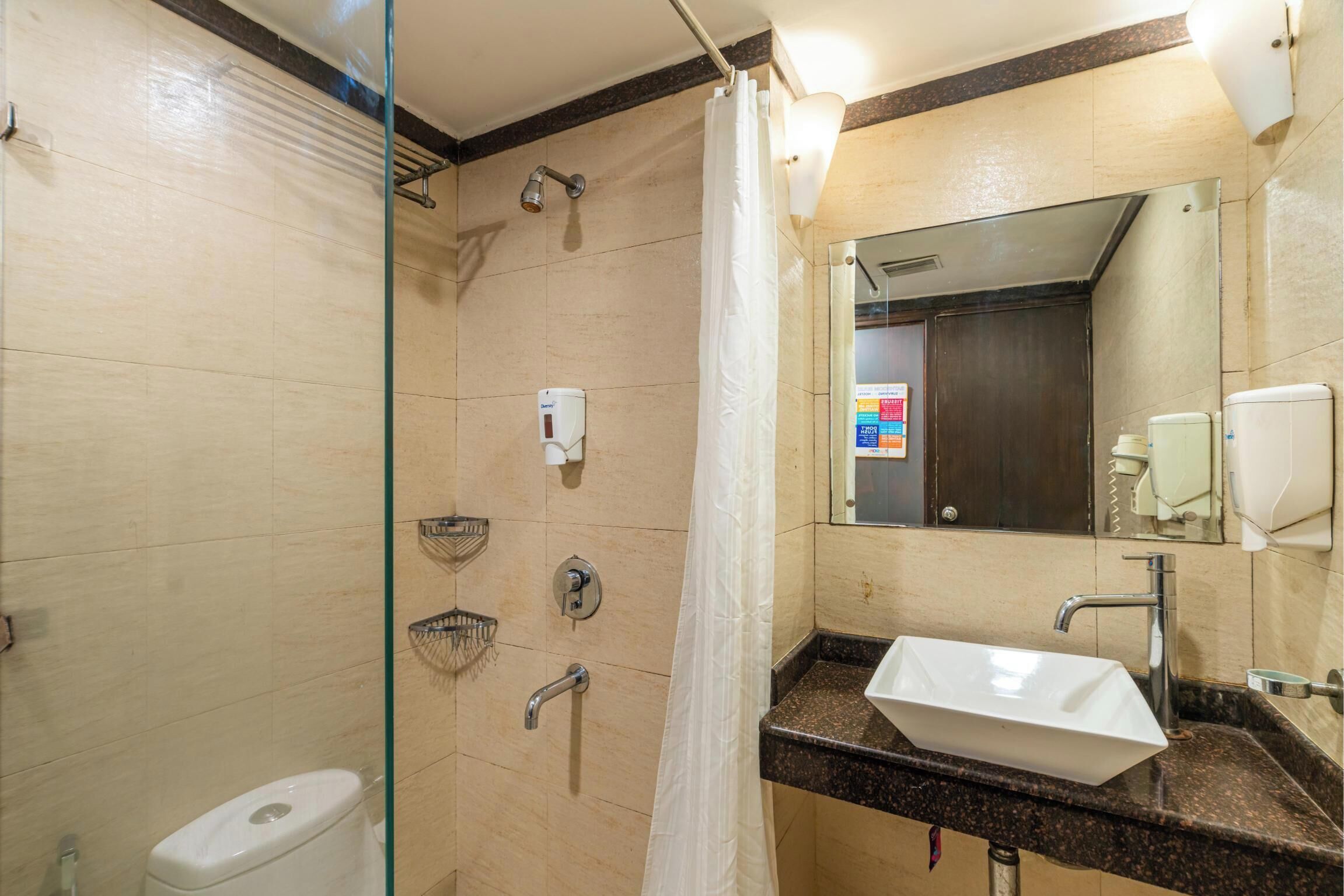 Un bagno moderno con cabina doccia in vetro, lavandino bianco e uno specchio grande.