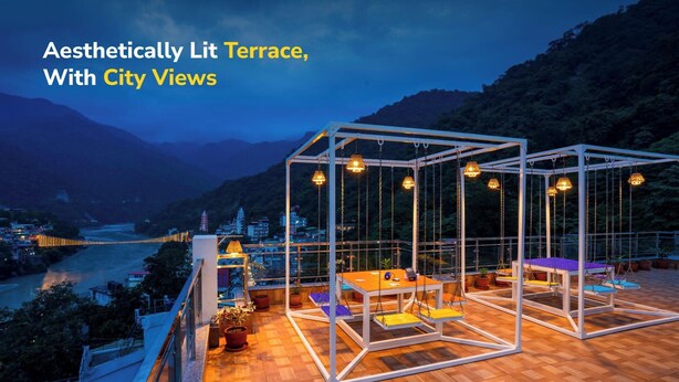 An aesthetically lit terrace with city views, featuring a swing area and seating. - goSTOPS Rishikesh, Lakshman Jhula (Yamkeshwar)